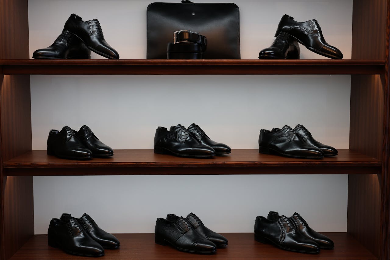 services-02 A stylish display of black leather shoes and accessories on wooden shelves in a store.